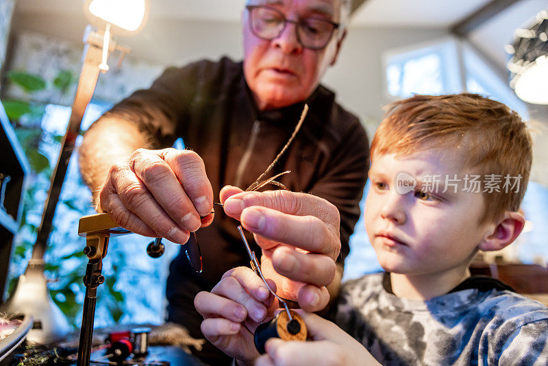 Grandfather Teaching his Grandson how to make Fly Fishing Flies at Home